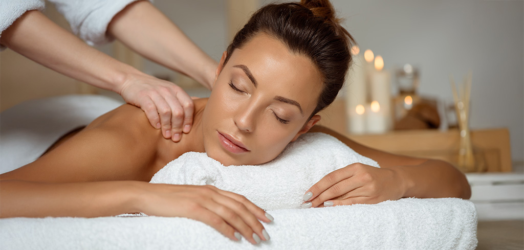 Žena relaxuje pri masáži chrbta, využívajúc zdravie a prospešné poukážky pre dokonalý oddych.