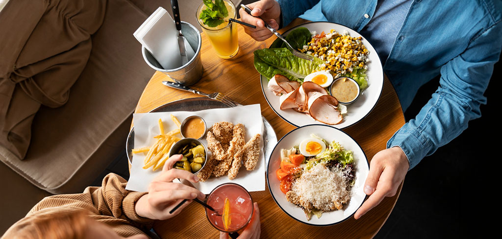 Kolegovia si pochutnávajú na zdravom obede pričom dbajú na stravovacie návyky.